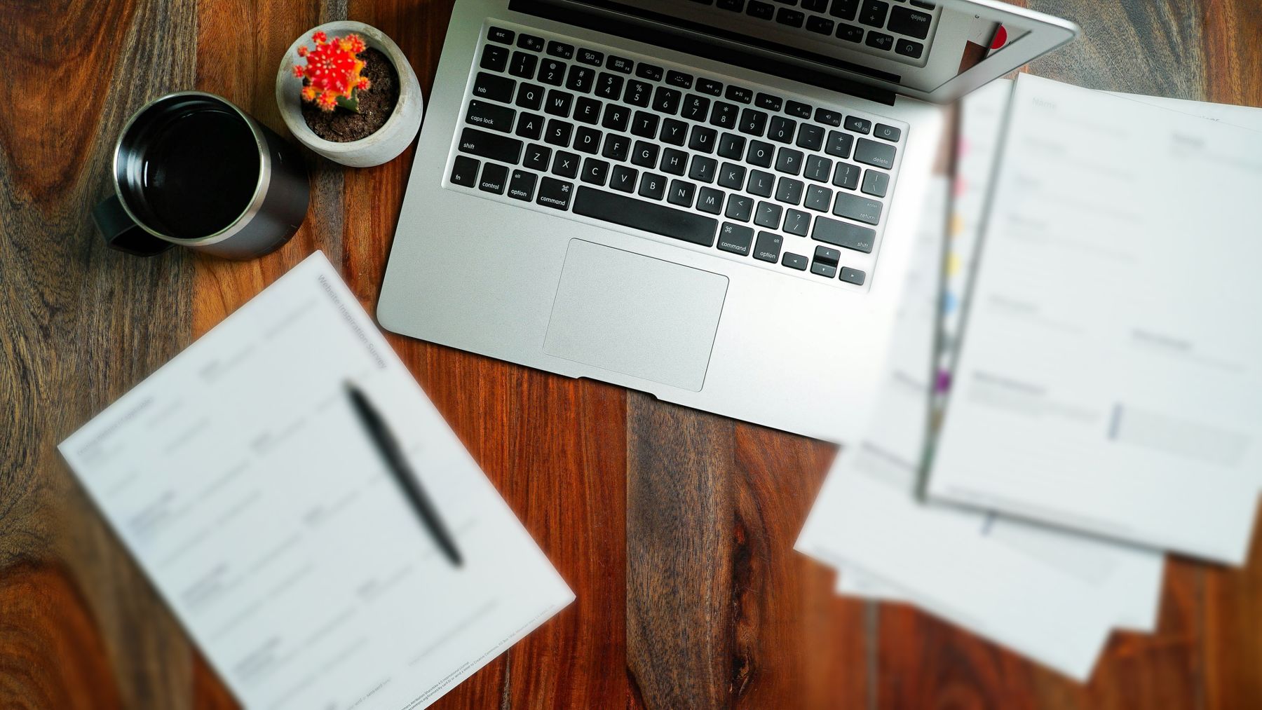 Secretária de trabalho com portátil, café e documentos